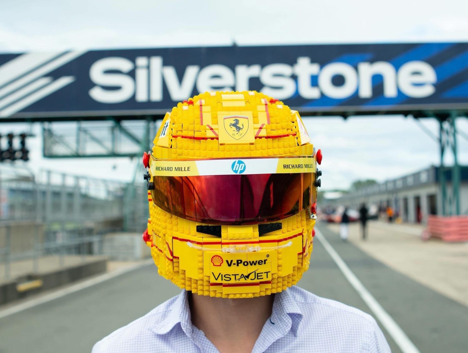 Life-sized Formula 1 helmet sculpture built from LEGO, photographed in the pit lane at Silverstone